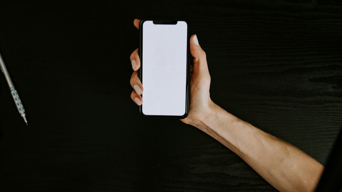 Hand holding a white smartphone against a clean backdrop, illustrating the iPhone Duo Philippines pre-order