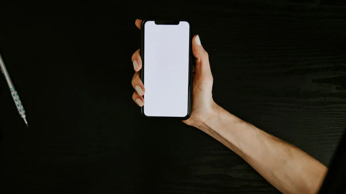 Hand holding a white smartphone against a clean backdrop, illustrating the iPhone Duo Philippines pre-order