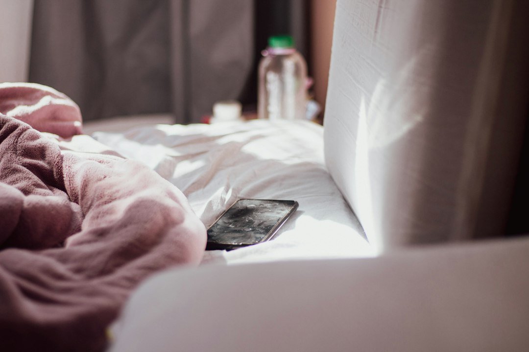 A smartphone resting on a bed, a common companion for those who sleep past 1 a.m.